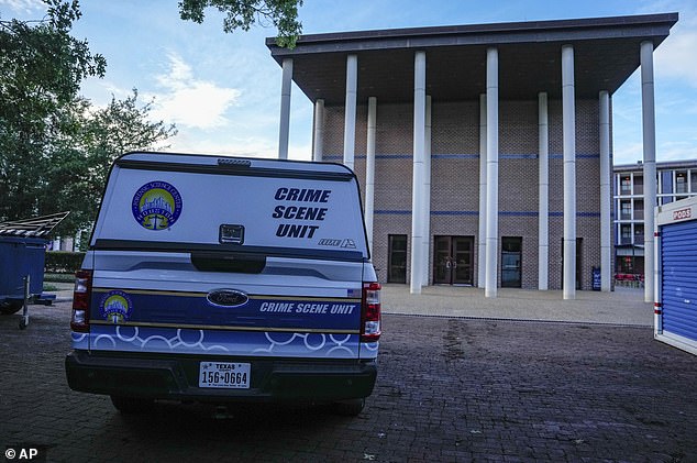 A police crime scene unit vehicle sits parked after the apparent murder-suicide on Monday.