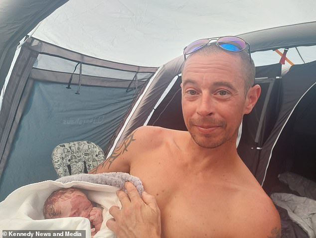 Stuart Doyle is pictured holding his baby daughter after giving birth in a tent.