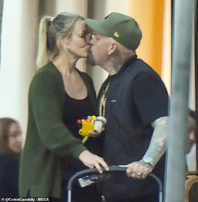 The couple was spotted standing outside a restaurant next to a stroller and shared a sweet kiss.