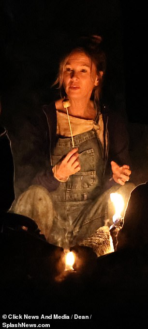 Bridget walked through the woods in a rain jacket and bucket hat before telling stories to the children around the fire.