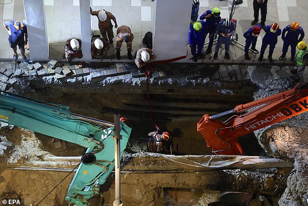 Rescue efforts continue overnight as fire crews inspect the sinkhole.