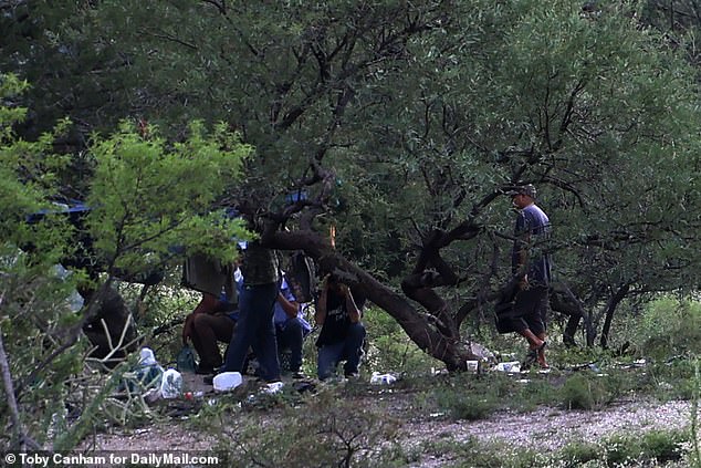 A group of migrants and smugglers settled a few meters from a hole in the border wall