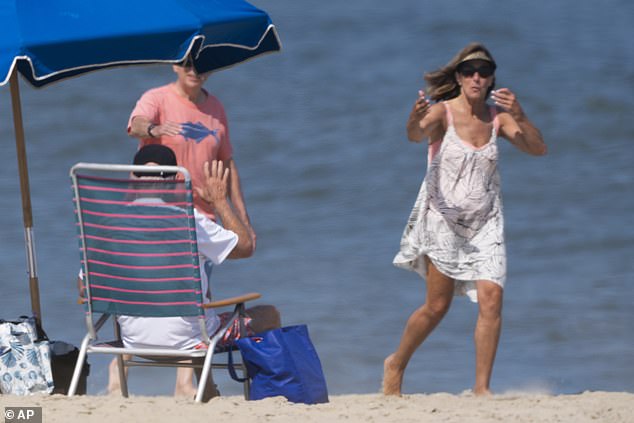 Passersby greet President Biden as he sits on the beach