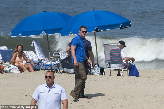 Secret Service agents surround President Biden as he enjoys time on the beach