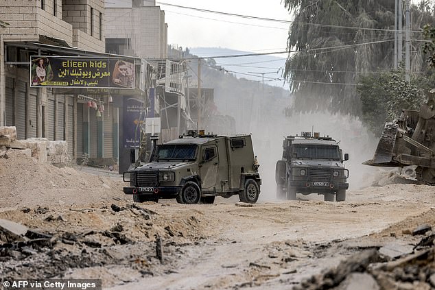 Israeli army armoured vehicles move along a road during a military operation in Tulkarm, in the northern occupied West Bank.