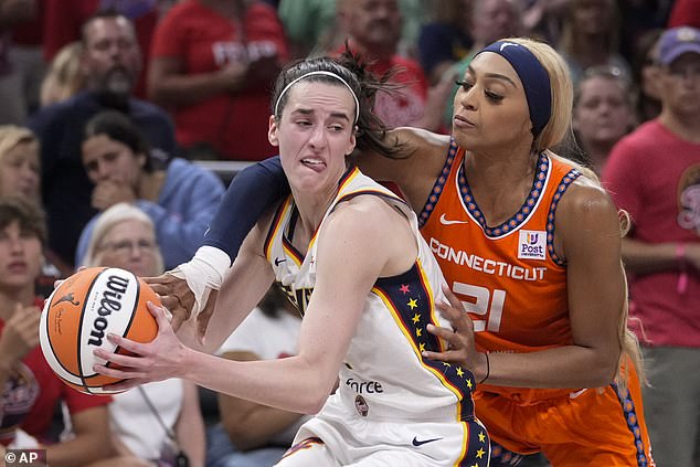 Connecticut Sun guard DiJonai Carrington fouls Indiana Fever guard Caitlin Clark (left)