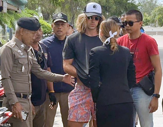 A handout photo provided by the Royal Thai Police shows a Spanish chef, murder suspect Daniel Jeronimo Sancho Bronchalo (center), being escorted by Thai police officers during a crime reenactment at a scene on Koh Phangan island, southern Thailand, August 7, 2023.