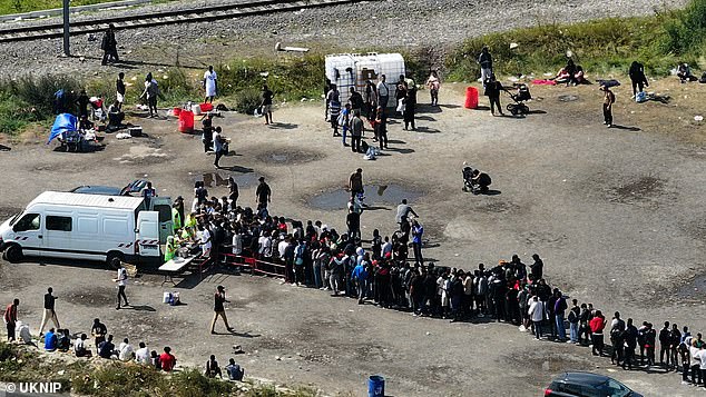 Large group of migrants receives help from charity workers in northern France