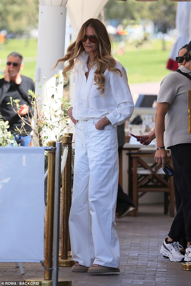 In one outfit, Elle looked effortlessly chic in a white linen shirt and wide-leg jeans, which she teamed with a pair of chunky beige sandals.