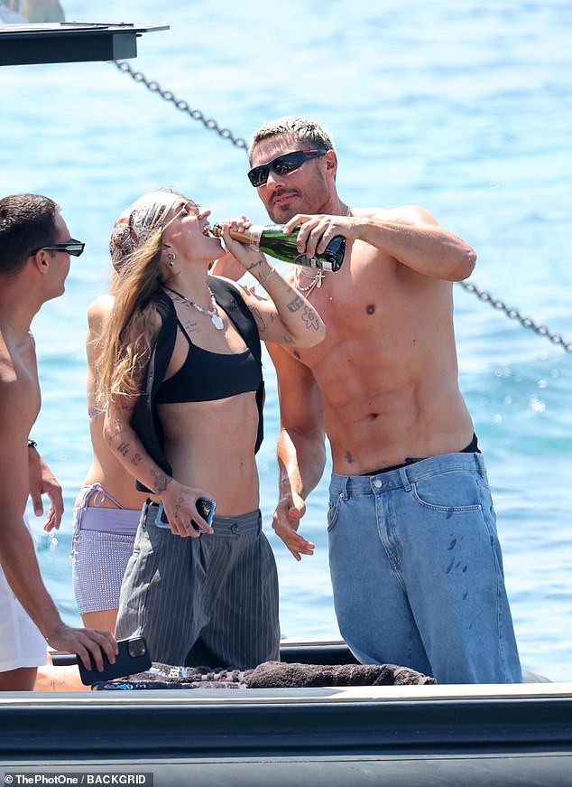 The loved-up duo were clearly in vacation mode, with G Flip more than happy to drink champagne straight from a bottle poured into his mouth by his friend and celebrity hairstylist Chris Appleton.