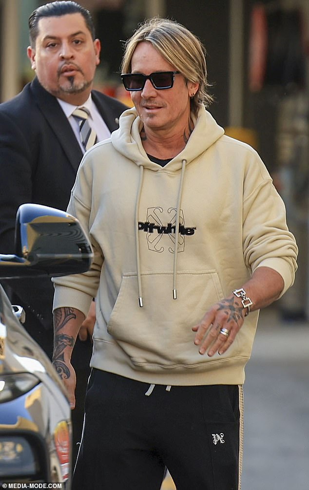 The New Zealand-born singer, 56, exuded confidence and style as he made his way through the bustling terminal in a $1,500 beige Off-White hoodie paired with black sweatpants.