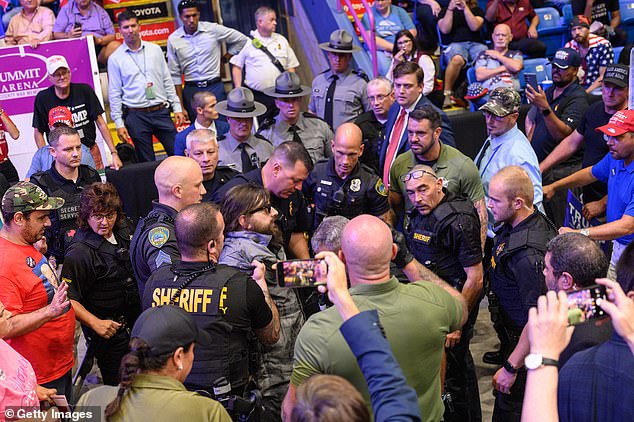 Officers managed to get him down from the metal fence as the crowd continued to chant slogans.