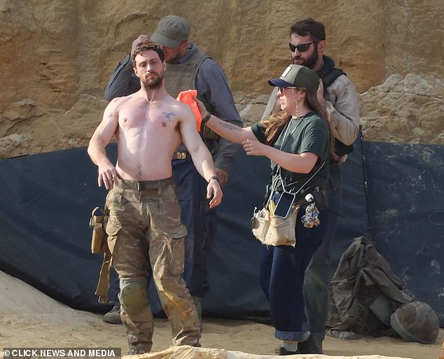 Taylor-Johnson being bathed by the makeup team while filming on set