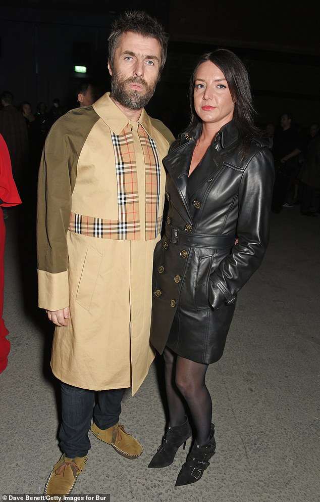 Liam Gallagher and his girlfriend Debbie Gwyther wearing a Burberry dress at the February 2018 show during London Fashion Week