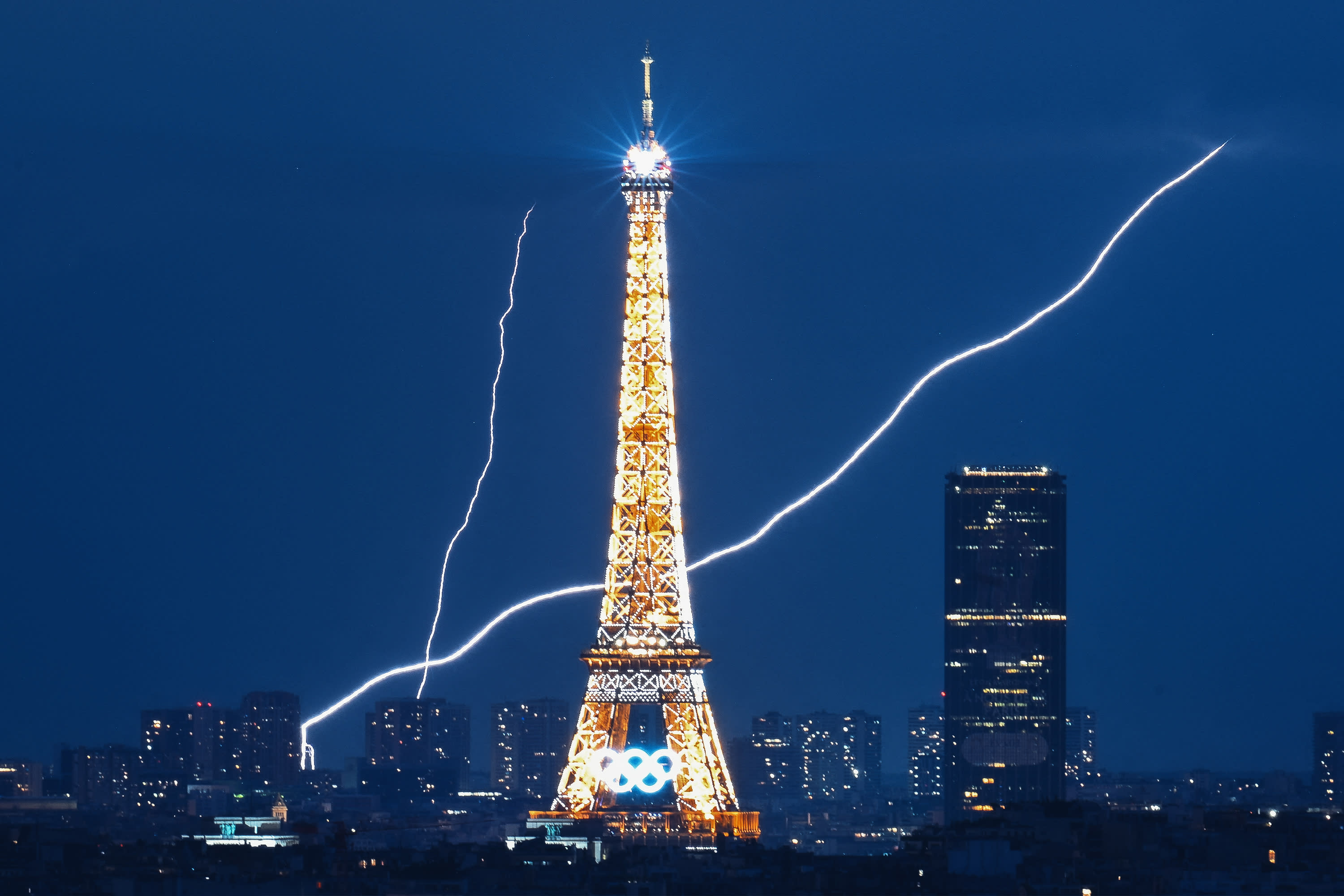 Lightning strikes near the Eiffel Tower during the Paris 2024 Olympic Games in Paris on August 1, 2024. (Photo by LUIS ROBAYO/AFP via Getty Images)