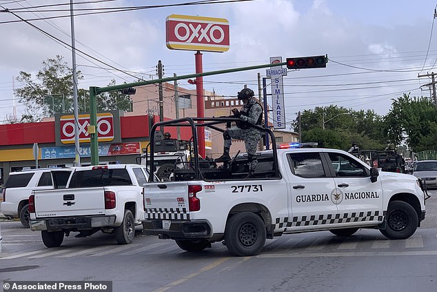 Mexican soldiers stand guard outside an Oxxo grocery store near the Tamaulipas Chamber of Commerce, where its president Julio Cesar Almanza was assassinated, in Matamoros, Mexico, Tuesday, July 30, 2024. (AP Photo/Veronica Cisneros)