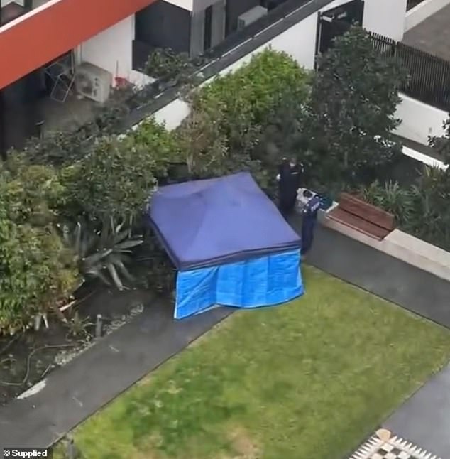 Police set up a blue tent at the unit's compound after the discovery of two bodies.