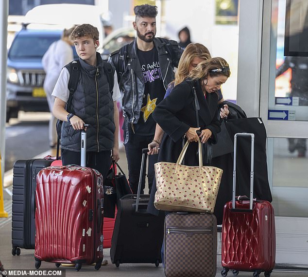 The 52-year-old pop star cut her best figure in a black coat paired with matching knee-high boots. Pictured with her son Ethan and boyfriend Adrian Newman.