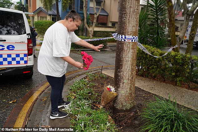 Grieving community members left flowers at the scene of the alleged murder.