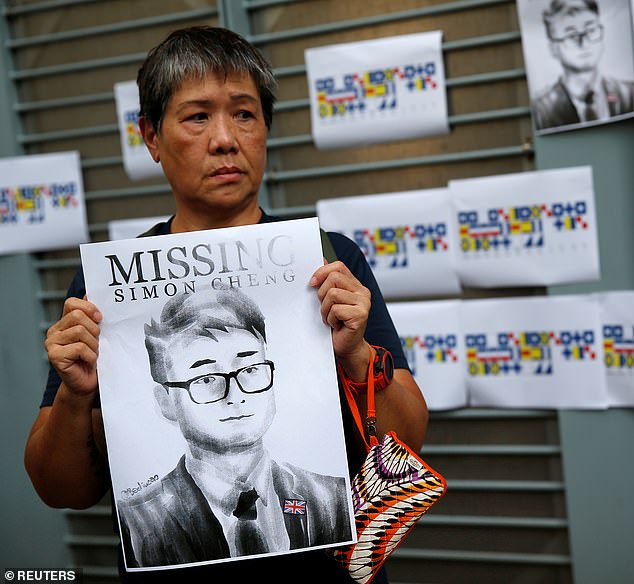 A woman in Hong Kong holds a poster of Mr Cheng