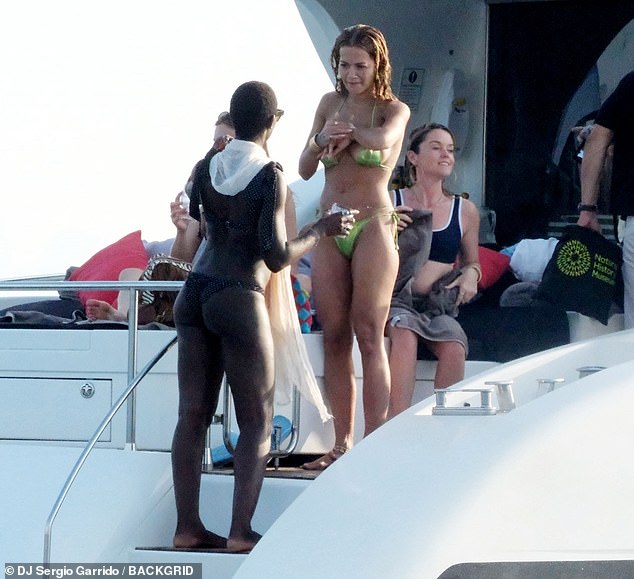 Jodie looked incredible as she laughed with Rita, teaming her tiny bikini with a white headscarf and a pair of stylish sunglasses.