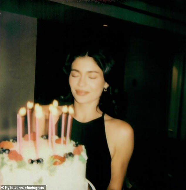 In a series of Polaroid snaps, Kylie glammed up in a black halter-style dress as she held a cake covered in sugary icing and lit candles in front of her.