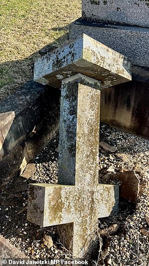 A cross toppled over a grave