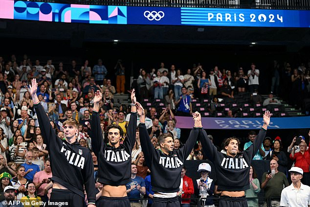 The 23-year-old (second from left) inadvertently revealed his abs after taking the podium.