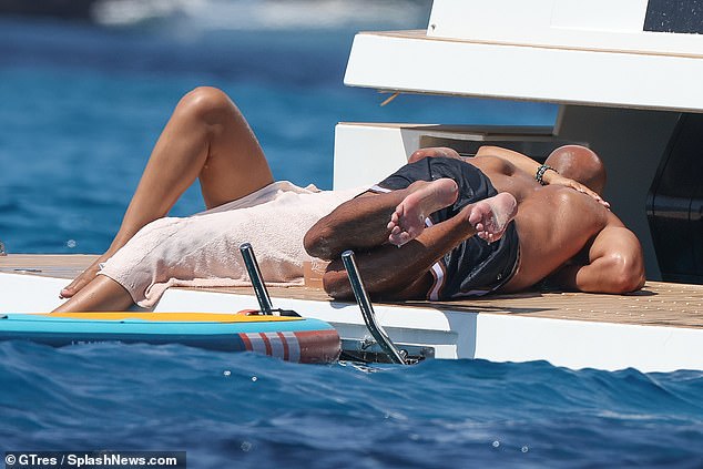 The couple, who share three children, enjoyed a dip in the ocean before sharing a kiss on the deck.