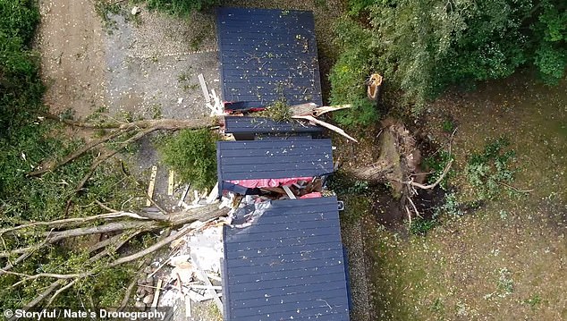 A house was completely split in two after huge trees fell directly on it, destroying the roof and walls.