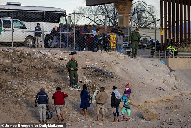 Migrants speak with a border agent near El Paso on December 16, 2022