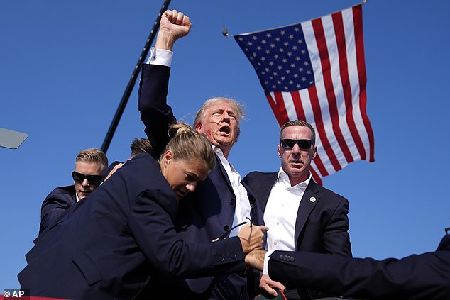 A blood-covered Donald Trump raised his fist after being shot in the ear by a sniper eight minutes after taking the stage at a rally in Butler, Pennsylvania.