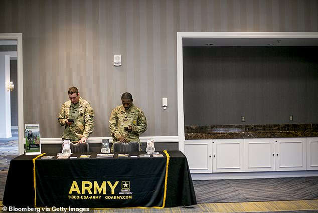 Army chiefs have spoken of the challenges of attracting new recruits, leading to a shortfall of as many as 15,000 soldiers last year. Pictured: Army recruiters at a job fair in Michigan