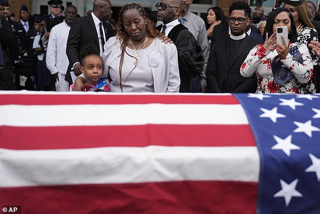 Chantemekki Fortson, the mother of slain airman Roger Fortson, right, along with her family look over Fortson's casket as they make their way to a cemetery during his funeral at New Birth Missionary Baptist Church, May 17, 2024 in Stonecrest, Georgia.