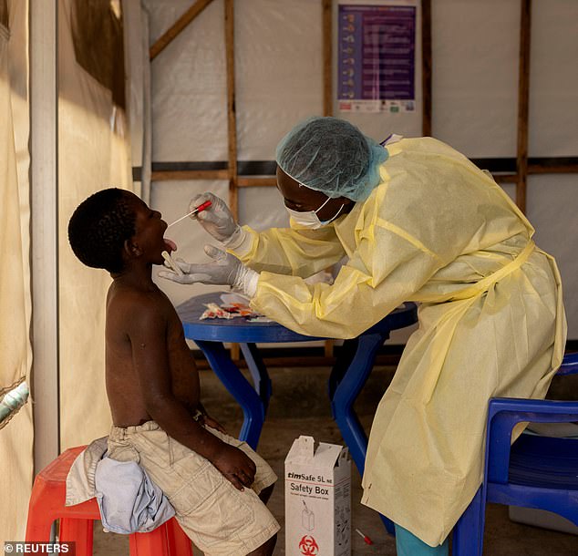 Christian Musema, a laboratory nurse, takes a sample from a child declared a suspected case of Mpox