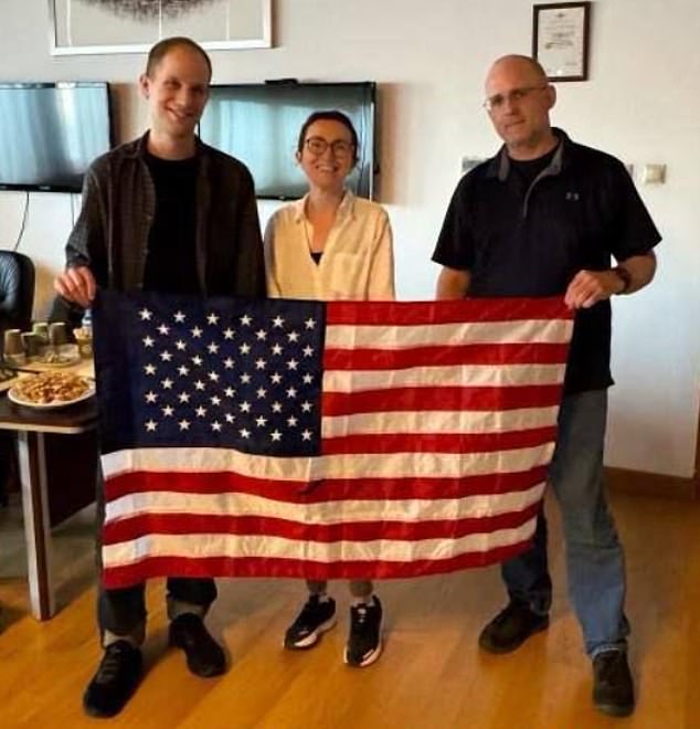 The trio posed with an American flag alongside returning citizen Alsu Kurmasheva (center), who was also released on Thursday.