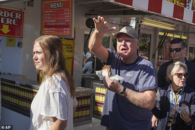 Walz is seen eating street food at the event alongside his daughter Hope (left) and wife Gwen (right). He did not answer any policy questions during his brief visit.