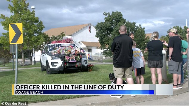 Community members gathered at the police department over the weekend to leave pink flowers on a patrol car in memory of Carson.