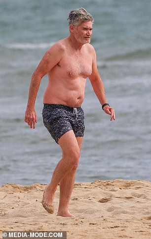 Hughesy looked relaxed as he took to the water in dark blue and white patterned shorts.