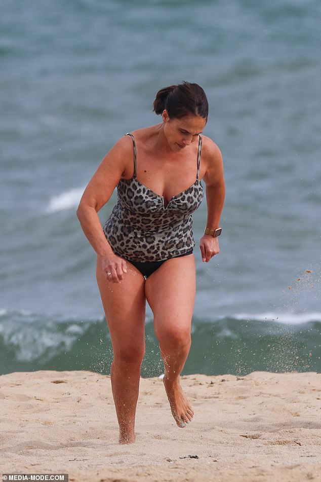 His wife Holly wore a leopard-print swimsuit before changing into a graphic Wrangler T-shirt after her dip.