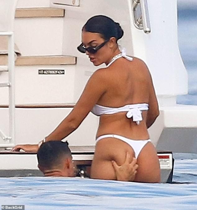 Georgina, 30, stunned in a white thong bikini that showed off her peachy bum, and Ronaldo couldn't resist giving it a cheeky squeeze.