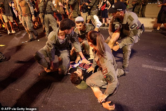 Israeli police officers detain a protester during clashes following an anti-government demonstration calling for the release of Israelis held hostage by Palestinian militants in Gaza since October.