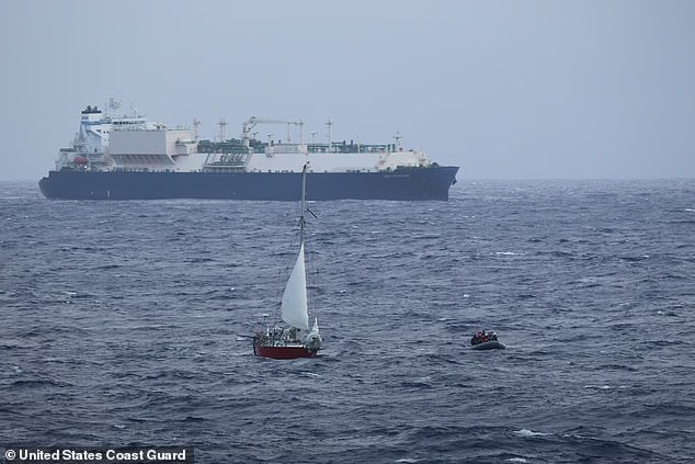 A small boat crew pulls away from the French-flagged sailing vessel Albroc after recovering the mother and daughter during rescue operations in the Pacific Ocean on August 26, 2024.