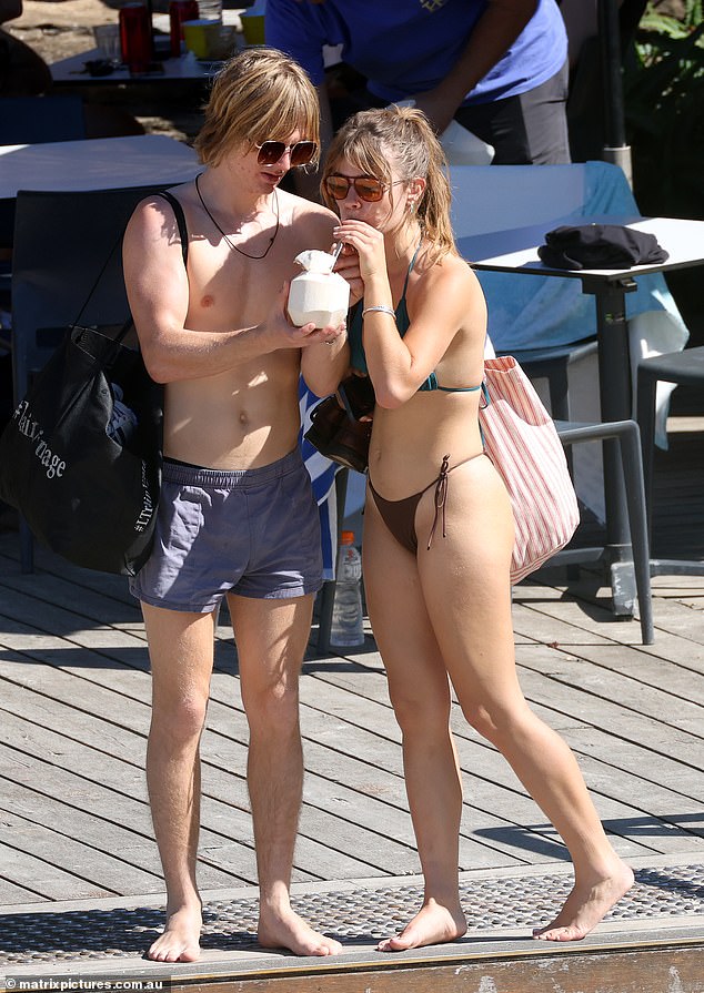 She added a pair of chic retro sunglasses and walked barefoot onto the sand.