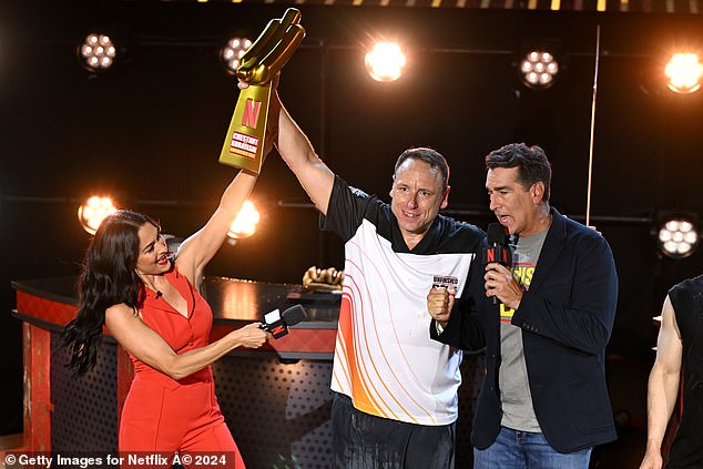 Nikki and co-host Rob Riggle (right) were photographed with winner Joey Chestnut after he emerged victorious.