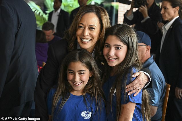 Kamala Harris poses for a photo with the daughters of a union member while campaigning with President Joe Biden at IBEW Local #5 in Pittsburgh