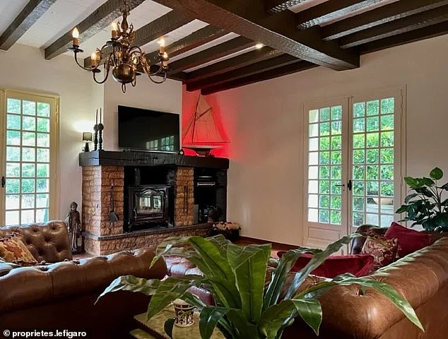 The house is filled with 19th-century style furniture, Chesterfield sofas and a fireplace.