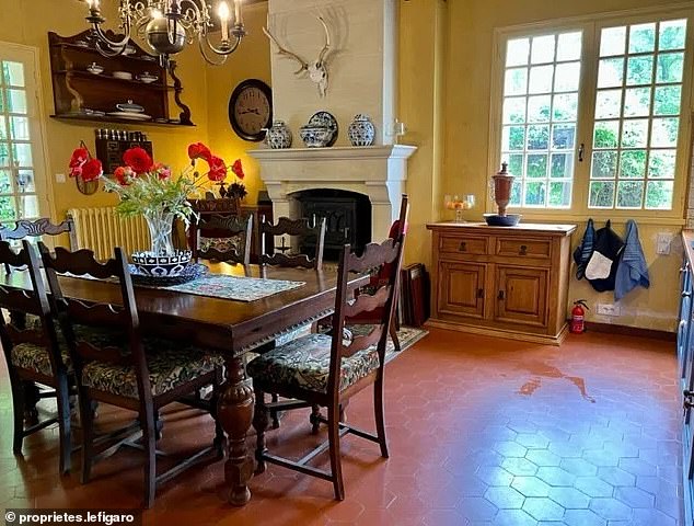 The house also features a living room with a separate kitchen (pictured), decorated with heavy wooden furniture.