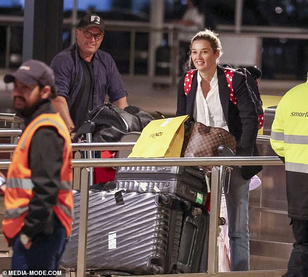 Returning to his native Australia, Karl, 50, was all smiles and looked happy to be home as he pushed his luggage onto ground transportation.