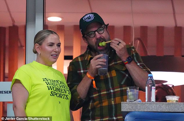 Jason donned a forest green baseball cap as he ate some melon balls during a break in the game.